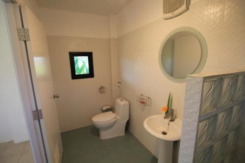 een badkamer met een toilet, een wastafel en een spiegel bij Country Retreat in Mae Rim