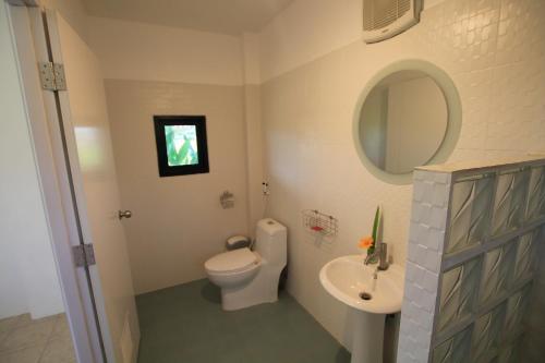 a bathroom with a toilet and a sink and a mirror at Country Retreat in Mae Rim