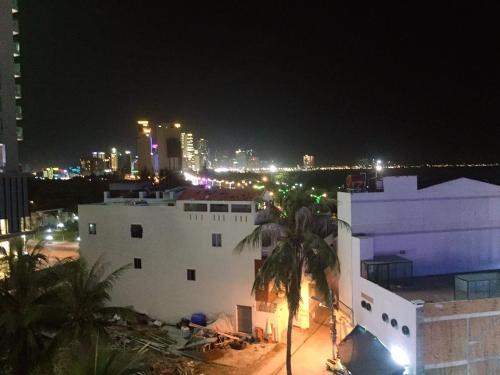 a white building with a city in the background at night at Khánh An Hotel in Nha Trang
