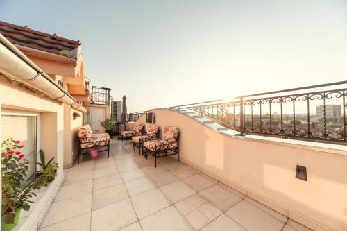 a balcony with chairs and tables on a building at New and Nice apartments in Kragujevac