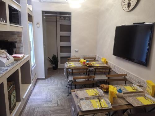 salon ze stołami i telewizorem z płaskim ekranem w obiekcie Guesthouse Luisella w Cagliari