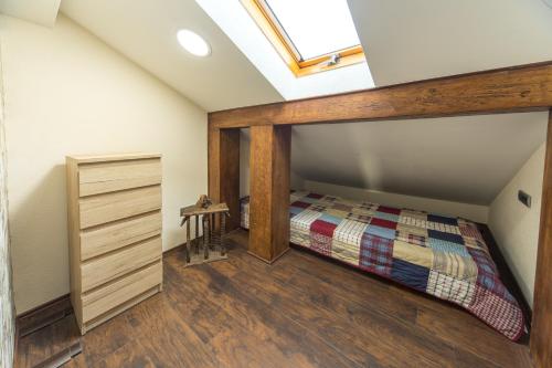 a attic bedroom with a bed and a skylight at New and Nice apartments in Kragujevac