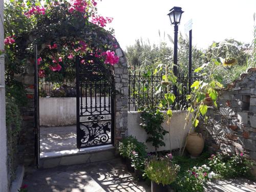 an entrance to a garden with a gate with flowers at Studios Margarita in Petalidhion