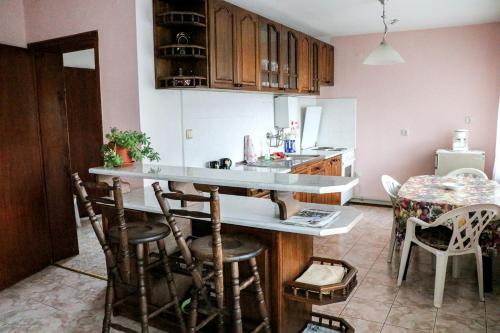 eine Küche mit einer Theke und einem Tisch mit Stühlen in der Unterkunft Nature Guesthouse in Varshets