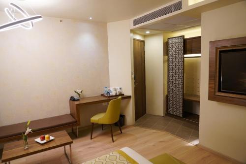 a hotel room with a desk and a yellow chair at IRA By Orchid Bhubaneswar in Bhubaneshwar