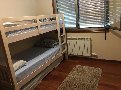 1 dormitorio con literas en una habitación con ventana en Playa America!, en Nigrán