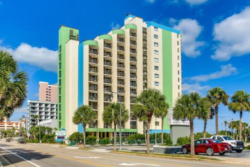 a tall building with palm trees in front of a street at Spectacular Oceanfront Condo in Myrtle Beach