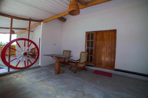 a room with a wooden table and a wagon wheel at Beach Lagoon Parans in Arugam Bay