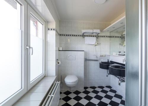 La salle de bains est pourvue de toilettes et d'un lavabo. dans l'établissement Hotel Berg en Dal, à Epen