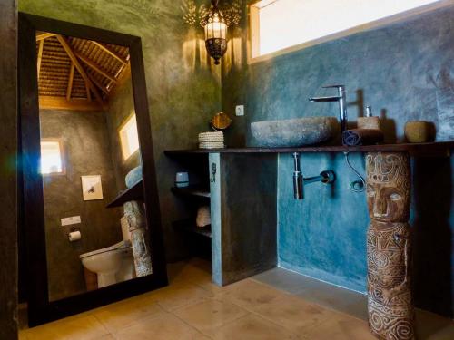 La salle de bains est pourvue d'un lavabo et d'un miroir. dans l'établissement Serenity Luxurious Beachfront Villa & Spa with private Infinity Pool, 8 Guests, à Gili Air