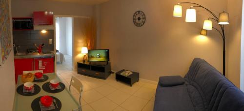 - un salon avec un canapé et une télévision dans l'établissement Brive Centre, à Brive-la-Gaillarde