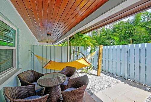 a hammock on a patio with a table and chairs at Siesta Key Palms Resort in Sarasota