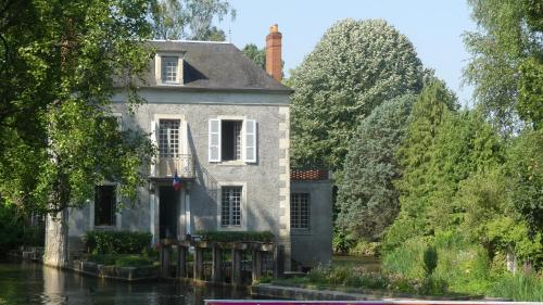een oud huis aan het water in een kanaal bij Maison du Moulin in Donzy