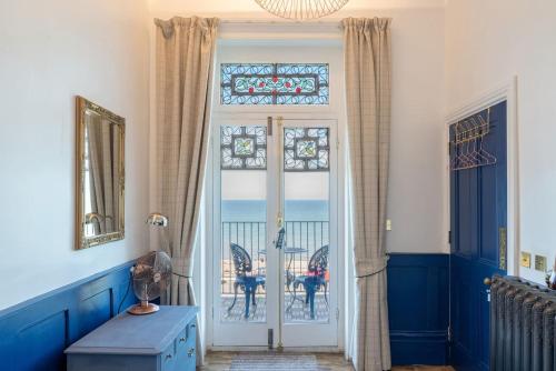 a room with a door with a view of the ocean at Bellevue By The Bay - Luxury Beach Pad, Panoramic Sea Views in Herne Bay