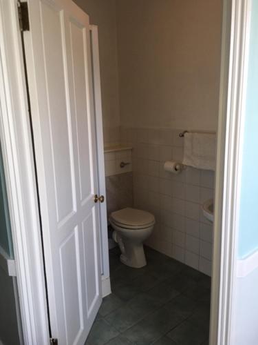 a white bathroom with a toilet and a sink at The Old Alma Inn Ltd in Chilham