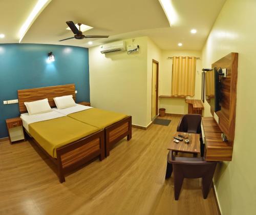 a bedroom with a bed and a table in it at Siva Residency in Mahabalipuram