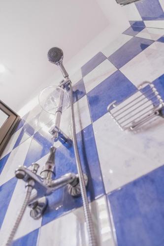 a water faucet on a blue and white tile floor at Appartement F4 Climatisé RDC à Totsi près de la maison ADEBAYOR in Lomé