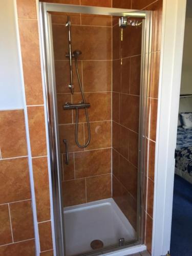 a shower with a glass door in a bathroom at The Old Alma Inn Ltd in Chilham
