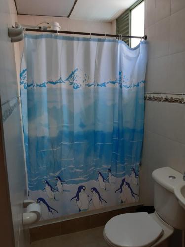 a bathroom with a shower curtain with dolphins on it at Casa de hospedaje coservisios in Tunja