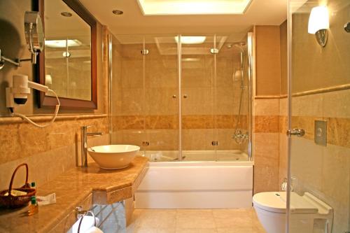 a bathroom with a tub, toilet and sink at CK Farabi Hotel in Ankara