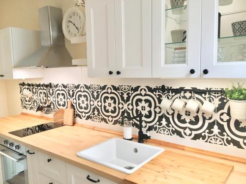 a kitchen with a black and white pattern on the wall at Alessia House in Bagnoregio