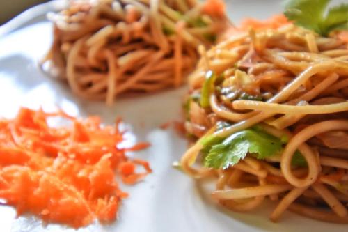 a plate of food with spaghetti and broccoli on it at Feel Like Home Nepal in Kathmandu