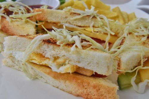 three sandwiches and chips on a white plate at Feel Like Home Nepal in Kathmandu
