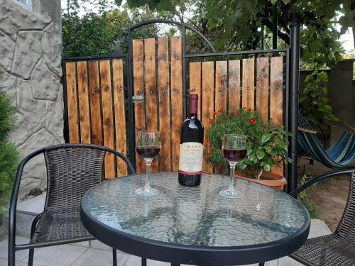 a bottle of wine sitting on a table with two glasses at Hotel Liva in Mtskheta