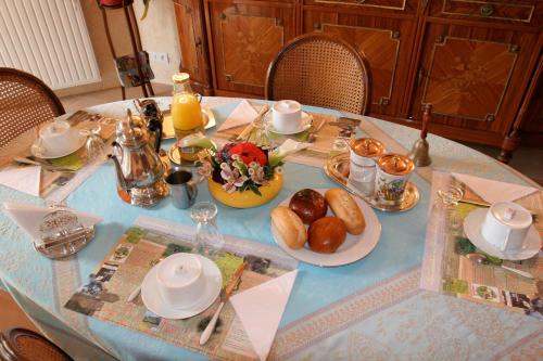 una mesa con un mantel azul con comida. en Chambres d'hôtes de Lunel, en Tresboeuf