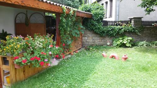 ein Hinterhof mit einem Garten mit Blumen und einem Zaun in der Unterkunft Borova House in Trjawna