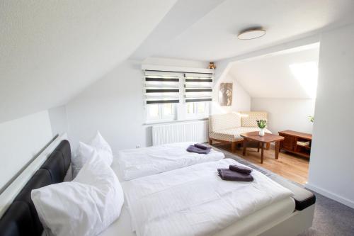 a bedroom with two white beds and a desk at Ferienhaus Sandy in Bad Elster