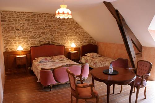 1 dormitorio con 1 cama, mesa y sillas en Chambres d'hôtes de Lunel, en Tresboeuf