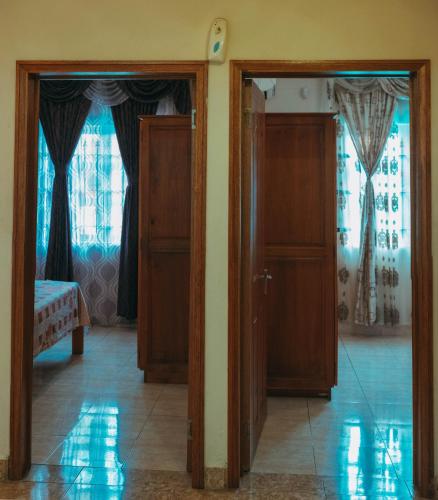 two doors open to a room with a bedroom at RS VILLA private apartment with pool and free wifi in Flic-en-Flac