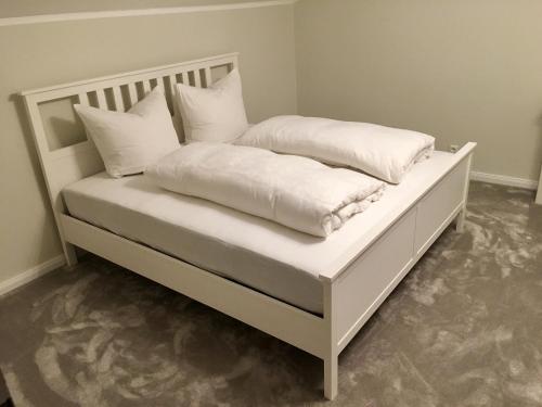 a white bed with white pillows on it at Traumhaftes Ferienhaus direkt am Tegernsee in Rottach-Egern