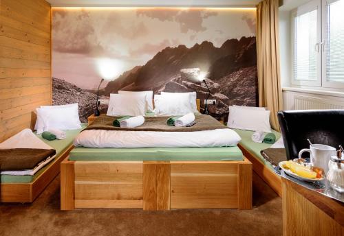 a bedroom with a bed with a painting on the wall at Vila Emma in Vysoke Tatry - Strbske Pleso