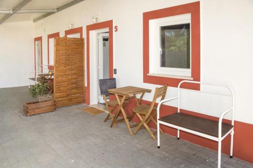 um pátio com uma mesa, cadeiras e uma cama em Casa das Pipas #5 no Pinhal Novo