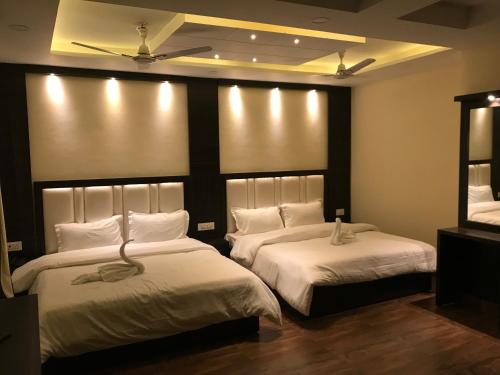 a bedroom with two beds with lights on the wall at Hotel Kabir Residency in Amritsar