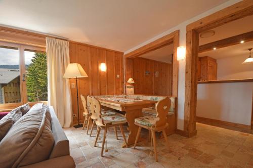a living room with a table and chairs and a couch at Grands Ducs 328 in Bagnes
