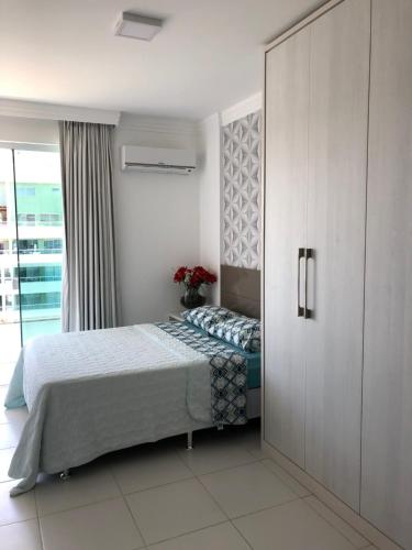 a bedroom with a bed and a sliding door at Apartamento Luxuoso com Vista in Ilhéus