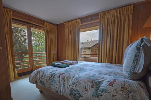 a bedroom with a bed and a large window at Grands Ducs 328 in Bagnes
