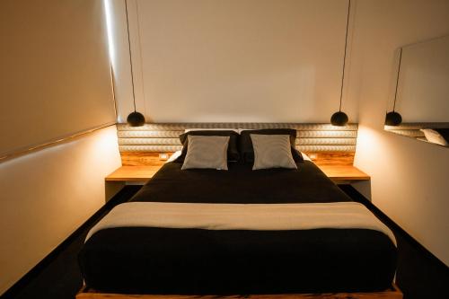 a bedroom with a large black bed with two pillows at Winter Suites Campos do Jordão - Capivari in Campos do Jordão