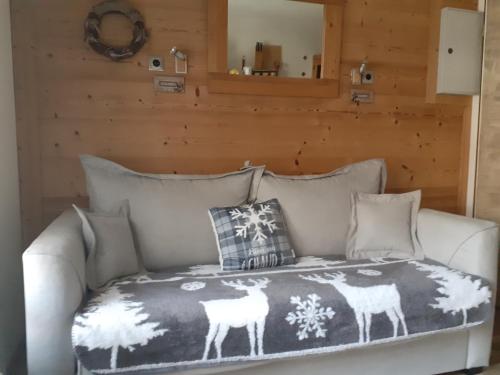 - un canapé blanc avec une couverture dans l'établissement Appartement Les Glieres, à Bourg-Saint-Maurice