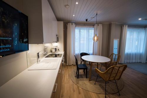 eine Küche und ein Esszimmer mit einem Tisch und Stühlen in der Unterkunft Upseeritalo in Seinäjoki
