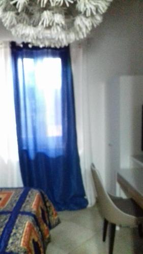 a bedroom with a window with a blue curtain at Villa Masullo in Mercogliano