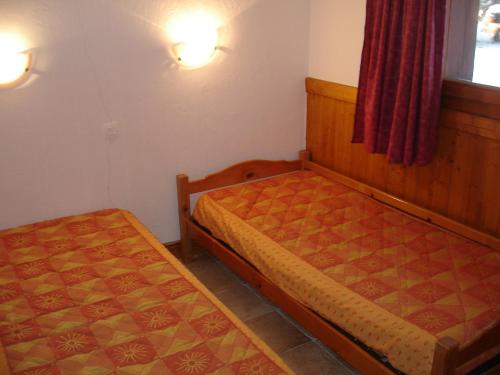 Un pat sau paturi într-o cameră la CHALET DANS LA NEIGE EDELWEISS ARCs 2000