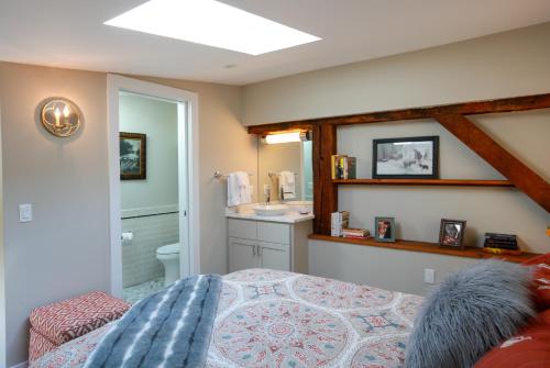 a bedroom with a bed and a bathroom with a sink at Woolverton Inn in Stockton