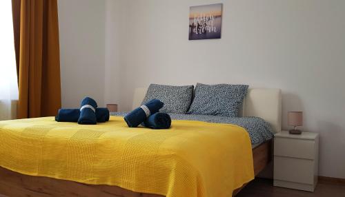 a bedroom with a yellow bed with two stuffed animals on it at Carpen View Residence in Săcele