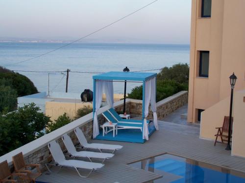 a blue gazebo on a balcony with the ocean at Sea Breeze Apartments Chios in Monolia