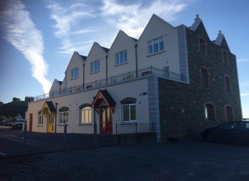 een groot wit gebouw met een grote toren bij Seaview Reenellen in Valentia Island