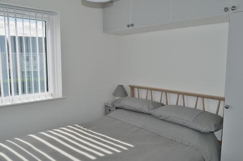 łóżko w białym pokoju z oknem w obiekcie 2 Rosemullion w mieście Perranporth